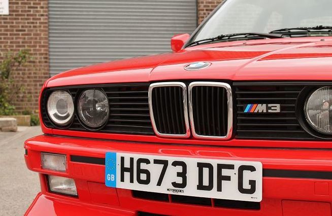 Face avant de BMW M3 E30 rouge avec calandre et logo M3