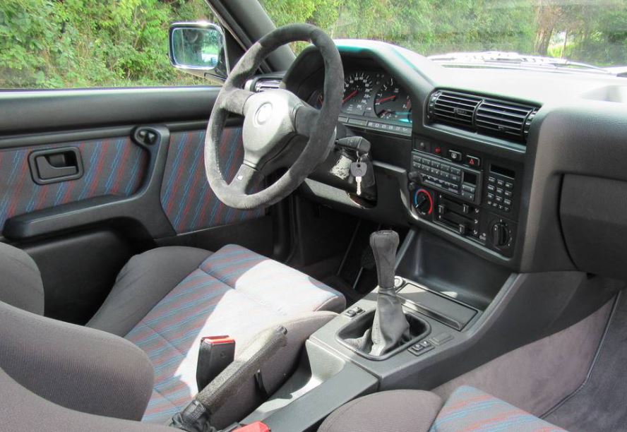 Intérieur de BMW M3 E30 avec sièges sport tissu et boîte manuelle