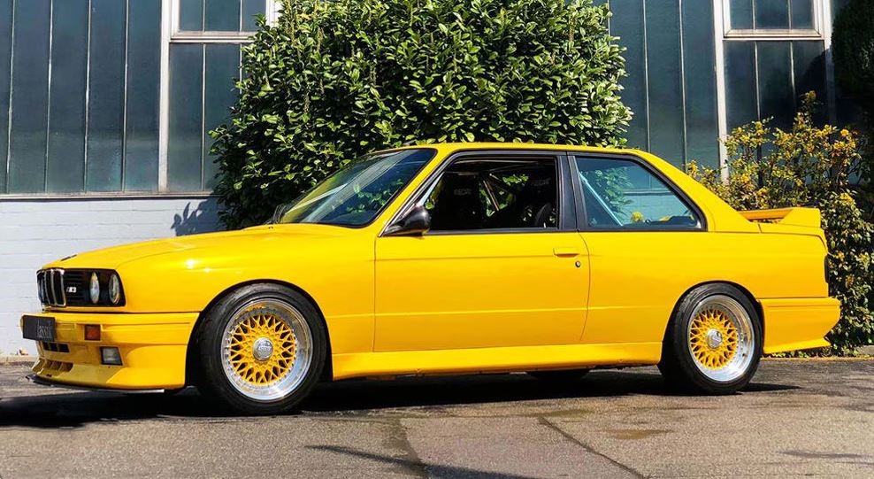 BMW M3 E30 jaune en stationnement, version sportive emblématique