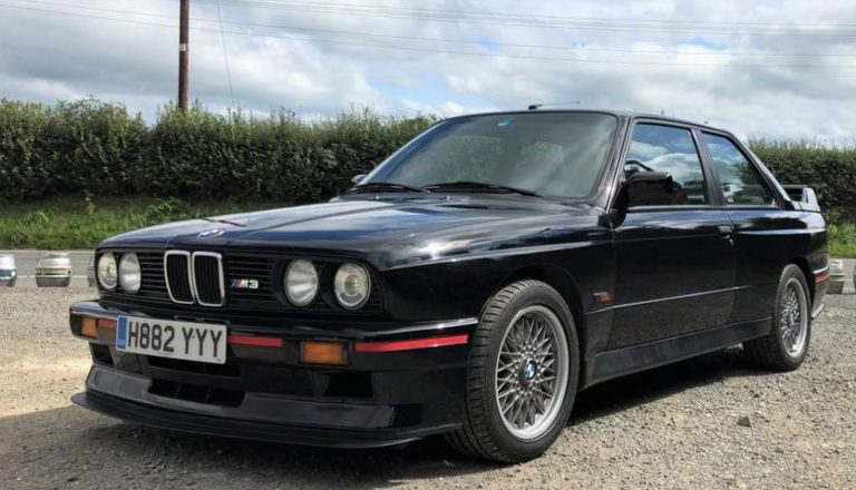 BMW M3 E30 noire vue avant gauche avec jantes BBS et élargisseurs d’ailes