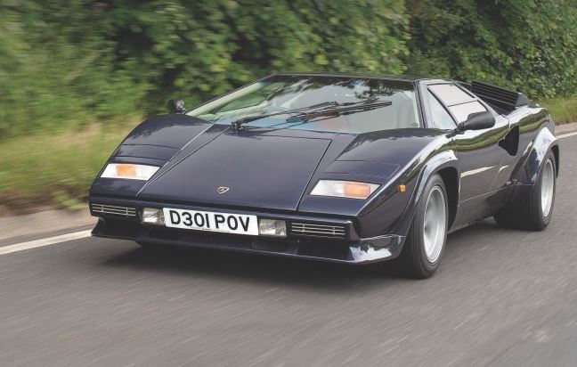 Lamborghini Countach noire en mouvement sur route, supercar italienne emblématique des années 80