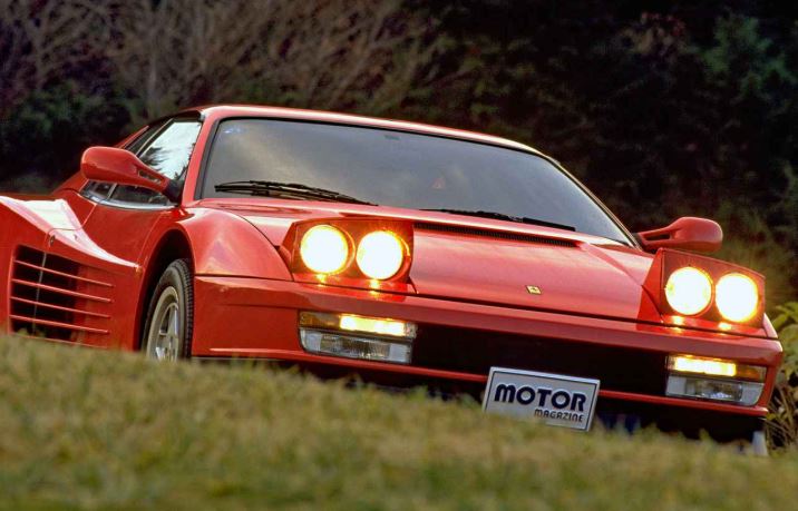 Ferrari Testarossa rouge en conduite, phares escamotables relevés