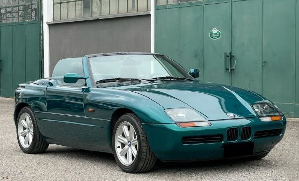 BMW Z1 verte stationnée devant un bâtiment industriel, roadster BMW photographié de face dans un environnement urbain