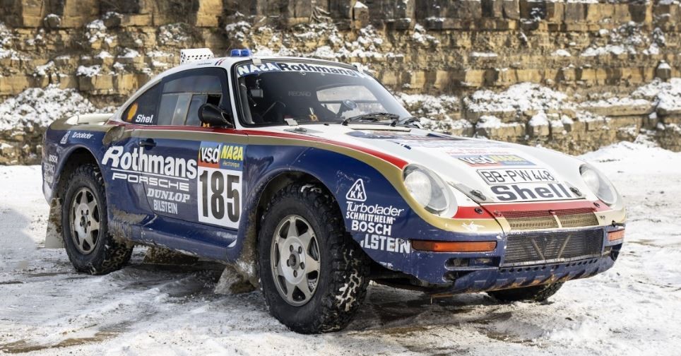 Porsche 959 de rallye aux couleurs Rothmans évoluant sur route enneigée, version compétition engagée en rallye-raid dans les années 1980