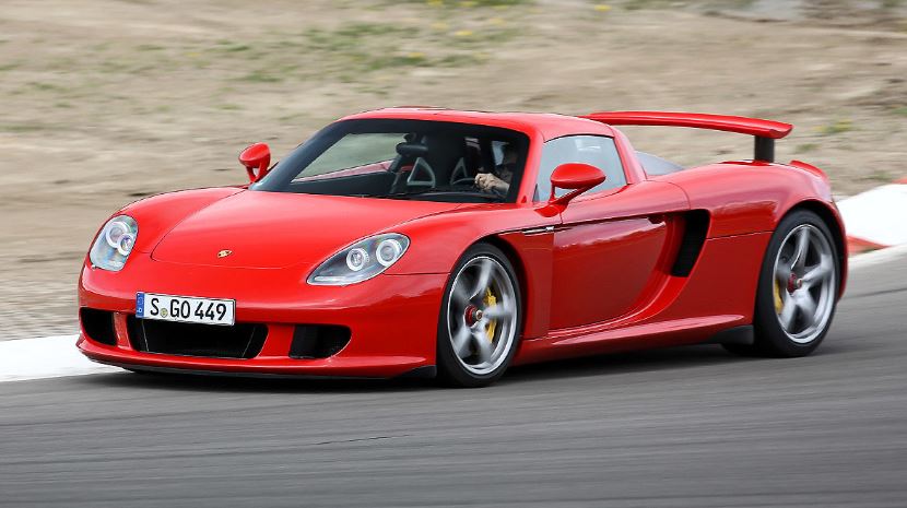 Porsche Carrera GT rouge sur circuit, supercar analogique sans assistance et voiture de collection moderne