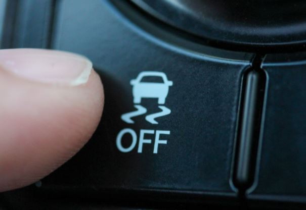 Bouton anti-patinage sur tableau de bord voiture avec symbole de perte d’adhérence