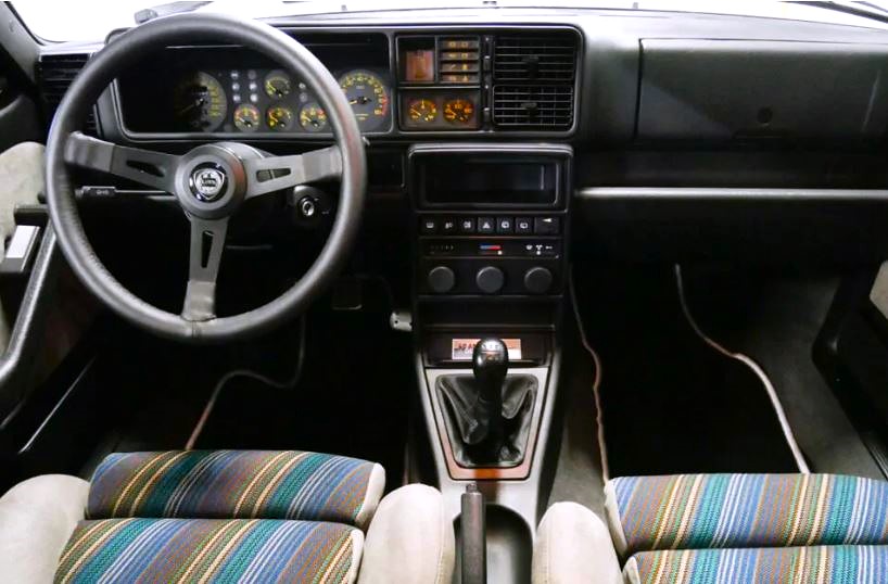 intérieur Lancia Delta Integrale avec volant sport tableau de bord analogique et sièges tissu d’origine