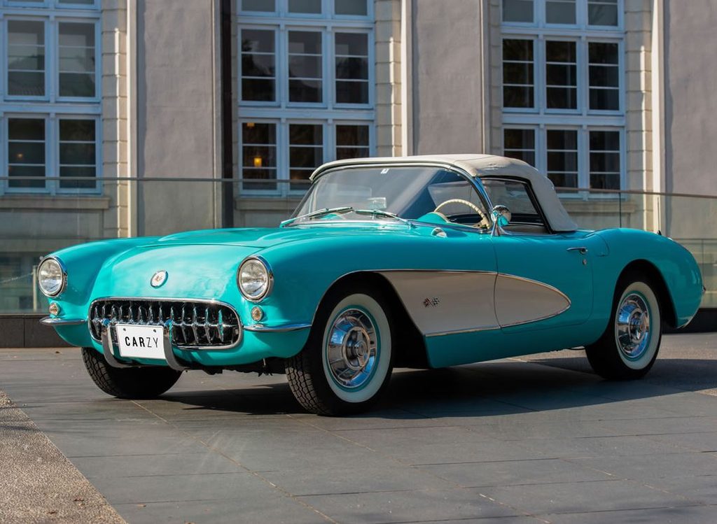 Chevrolet Corvette C1 cabriolet turquoise avec capote blanche, vue de trois quarts avant gauche.