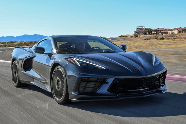 Chevrolet Corvette C8 Stingray grise en pleine accélération sur circuit, vue de trois quarts avant.
