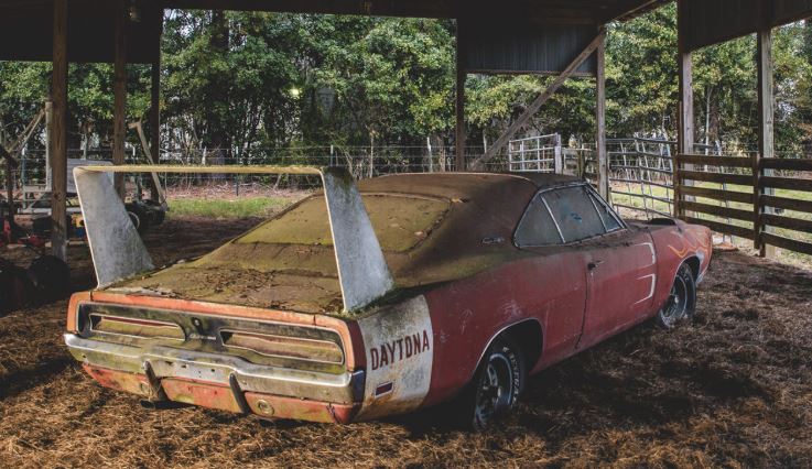 Dodge Charger Daytona abandonnée dans une grange ouverte couverte de poussière