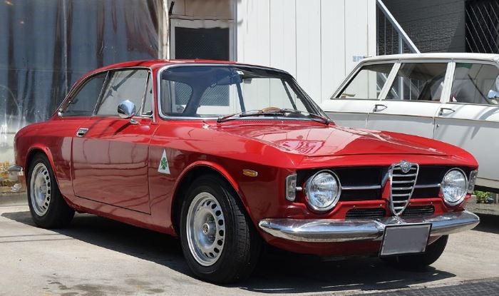 Alfa Romeo Giulia GT Junior rouge stationnée, voiture ancienne au design italien intemporel