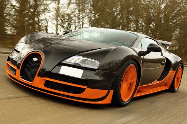Bugatti Veyron noire et orange roulant à vive allure, vue avant agressive et aérodynamique