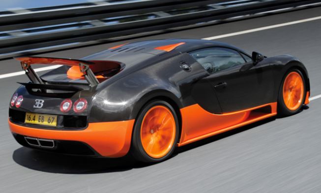 Bugatti Veyron noire et orange roulant à vive allure, vue avant agressive et aérodynamique