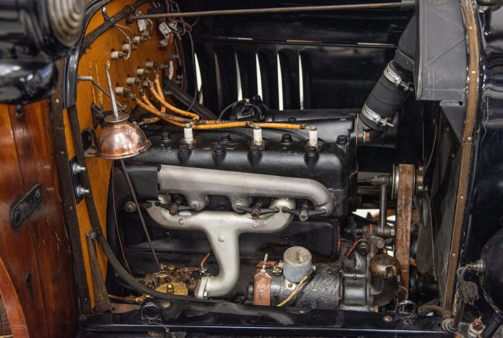 Moteur quatre cylindres en ligne de 2,9 litres de la Ford Model T, avec bougies d'allumage, collecteur d'échappement et accessoires mécaniques d'époque.