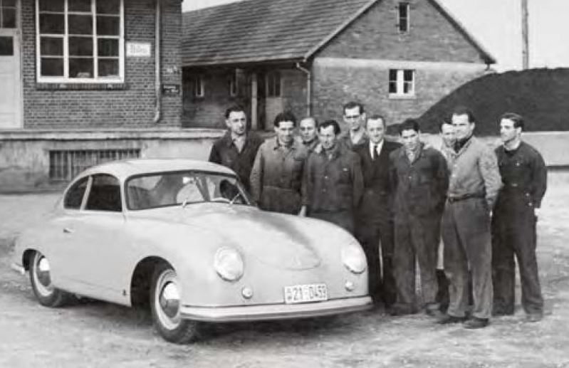 Une des première Porsche 356 entourée d’ouvriers devant l’atelier de production