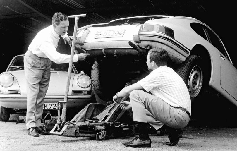 Ferdinand Alexander Porsche et son père Ferry observant une Porsche 911 en atelier