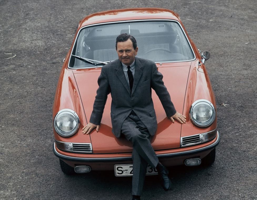 Ferdinand Alexander Porsche assis sur le capot d’une Porsche 911 dans les années 1960