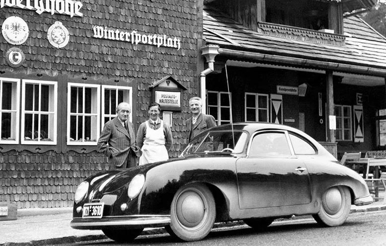 Ferdinand Porsche debout devant une auberge alpine après la guerre