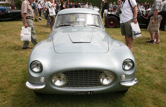 Vue de face d’une Fiat 8V gris clair stationnée sur une pelouse lors d’un rassemblement de voitures anciennes