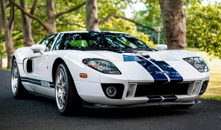 Ford GT40 blanche avec bandes bleues vue de face trois quarts sur route avec design moderne inspiré du modèle original