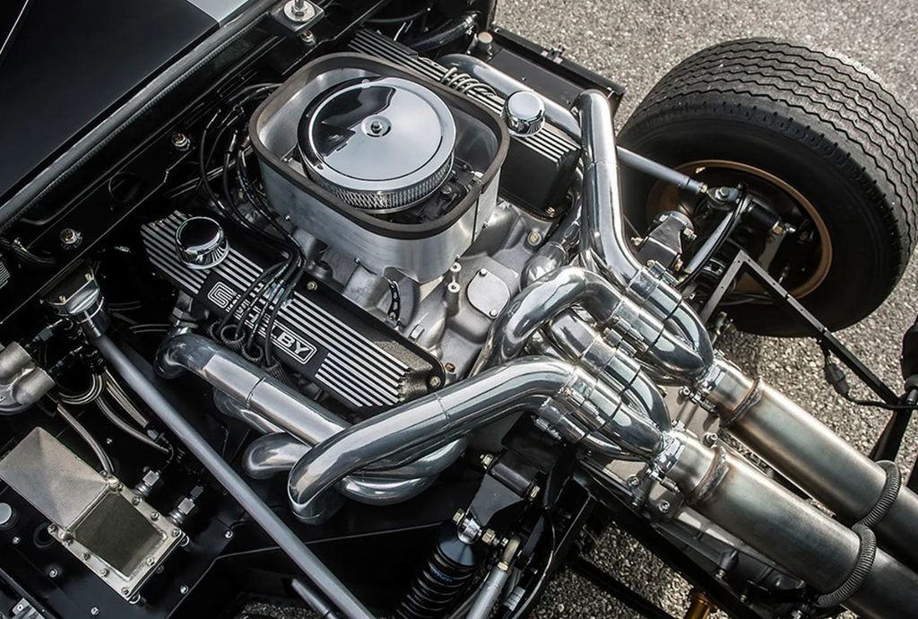Moteur V8 Shelby d'une Ford GT40, avec filtre à air central, échappements chromés et suspension arrière apparente.