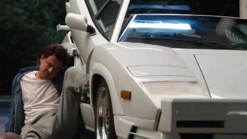 Lamborghini Countach blanche des années 80 stationnée devant un garage de nuit