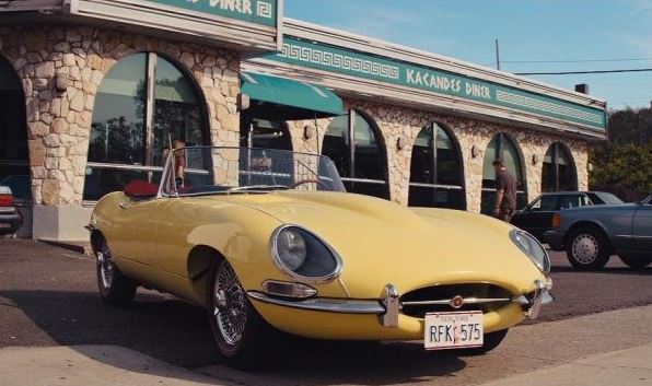 Jaguar Type E cabriolet jaune garée devant un diner américain en bord de route