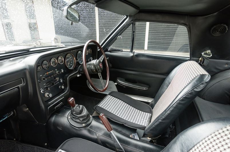 Intérieur de Mazda Cosmo Sport 110S avec tableau de bord et volant en bois