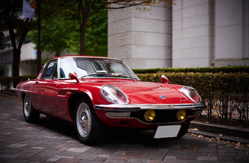Mazda Cosmo Sport 110S rouge stationnée en ville, design futuriste japonais des années 60