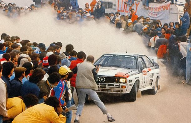 Audi Quattro entourée de spectateurs en spéciale rallye groupe B
