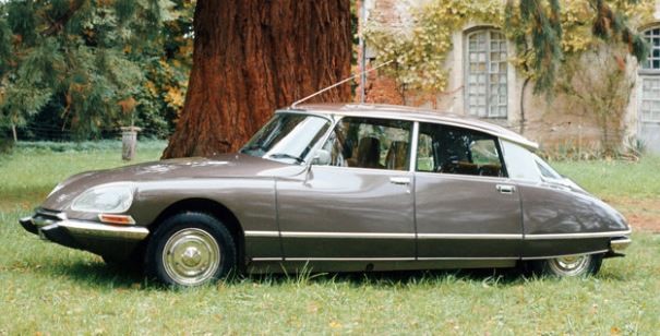 Citroën DS grise stationnée sur l’herbe dans un décor résidentiel