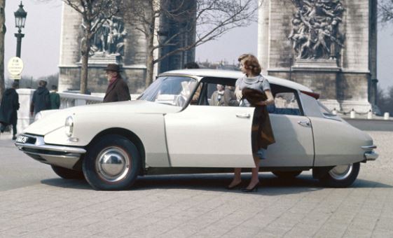 Citroën DS stationnée en ville avec une passagère descendant de la voiture
