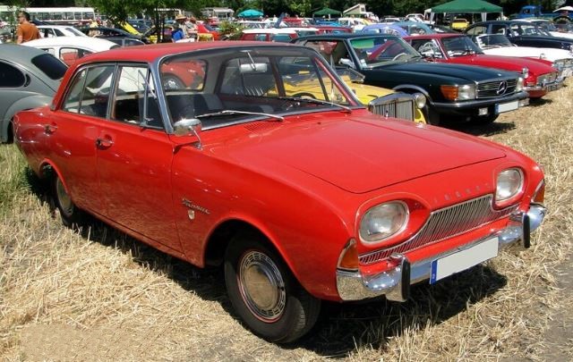 Ford Taunus noire stationnée de nuit dans une rue résidentielle
