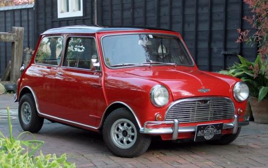 Mini rouge stationnée dans une cour pavée devant une maison