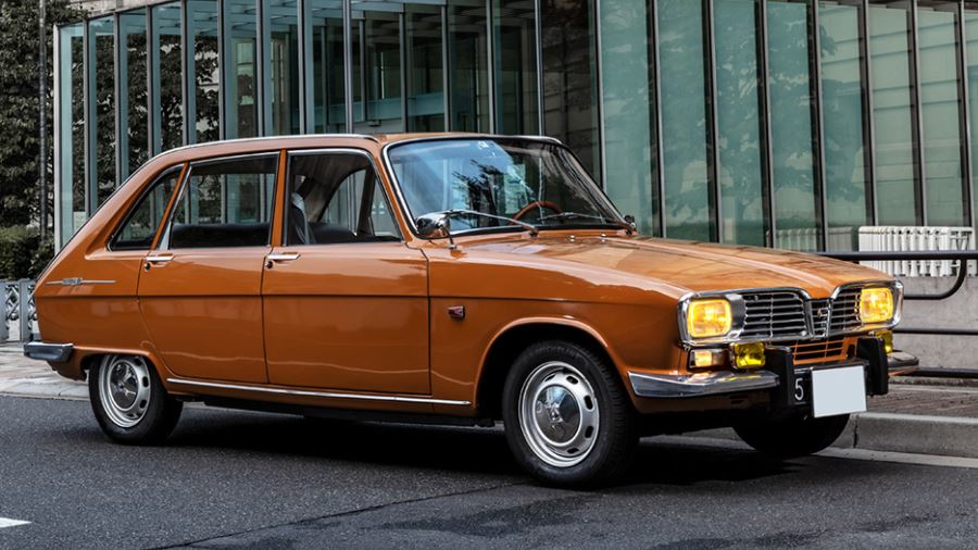 Renault 16 orange stationnée devant un bâtiment moderne
