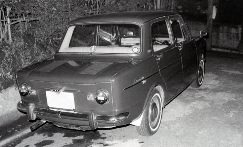Simca 1000 sombre stationnée de nuit sur une route enneigée