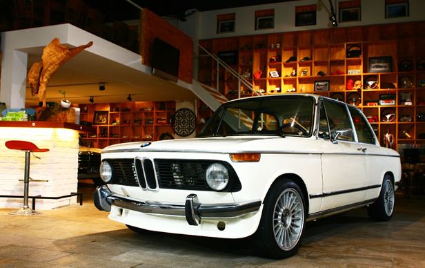 BMW 2002 tii exposée en salon, berline sportive classique allemande