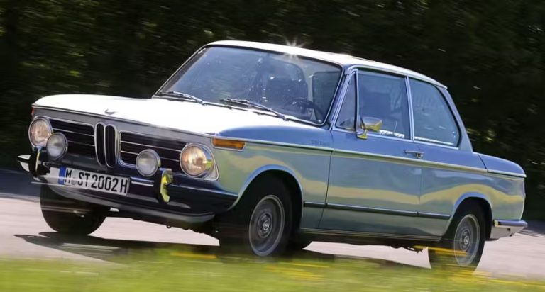 BMW 2002 tii grise roulant sur route, berline sportive allemande des années 70