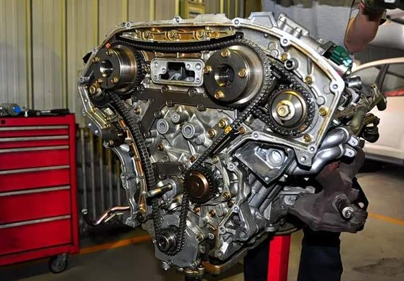 Distribution moteur ouverte avec chaîne métallique et pignons visibles