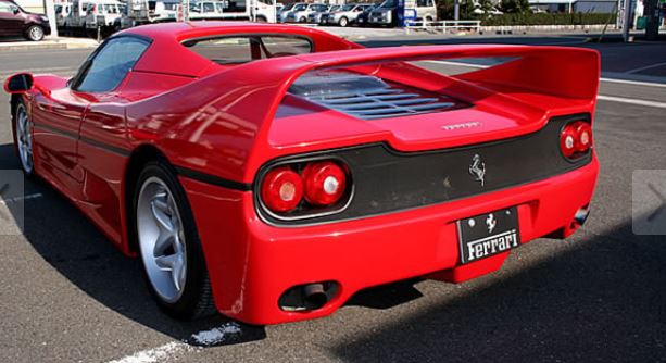 Vue arrière d’une Ferrari F50 rouge avec aileron et feux ronds caractéristiques