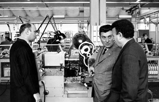 Ferruccio Lamborghini discutant avec des techniciens dans un atelier de fabrication