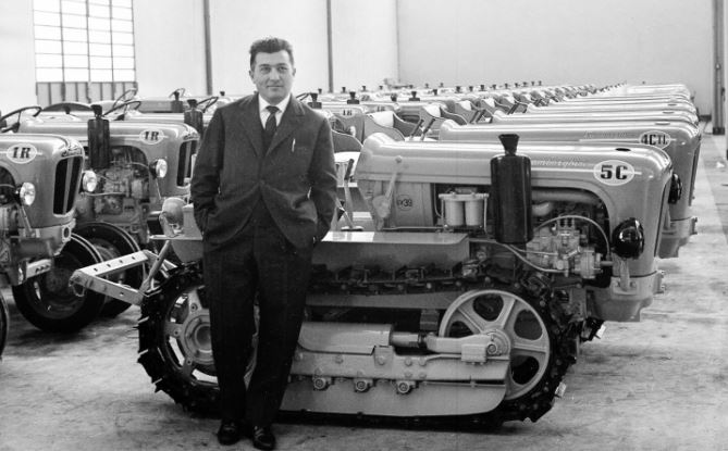Ferruccio Lamborghini posant devant une rangée de tracteurs Lamborghini dans son usine, années 1950