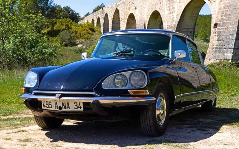 Citroën DS 23 IE noire vue trois quarts avant devant un ancien viaduc en pierre