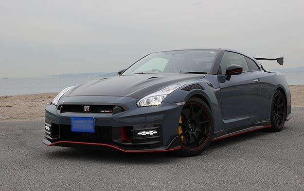 Nissan GT-R R35 Nismo gris vue trois quarts avant sur route en bord de mer