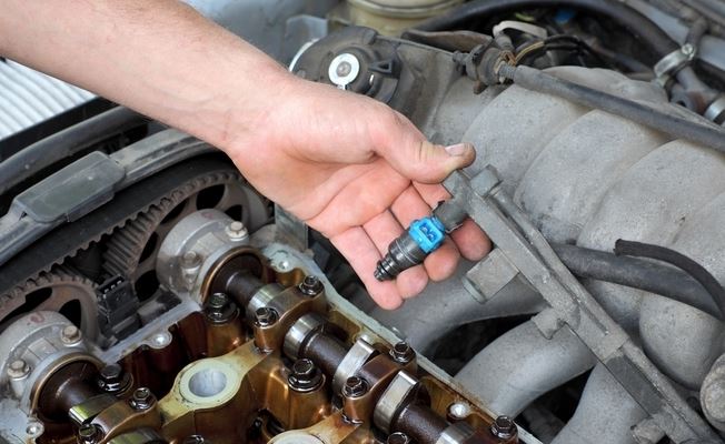 Démontage d’un injecteur sur une rampe d’injection essence, vue moteur ouvert