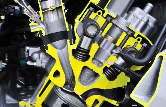 Coupe d’un injecteur automobile pulvérisant le carburant dans la tubulure d’admission