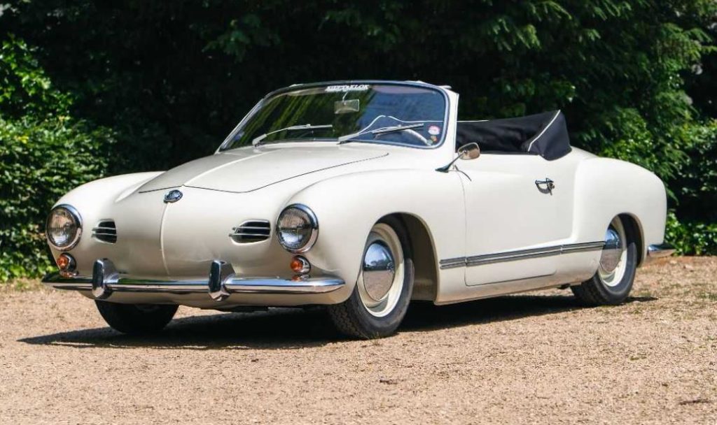 Volkswagen Karmann Ghia cabriolet beige, vue trois quarts avant, garé sur un chemin en gravier