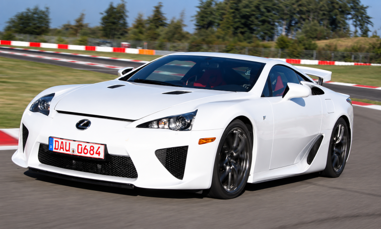 Lexus LFA blanche sur circuit, vue de trois quarts avant en pleine accélération.