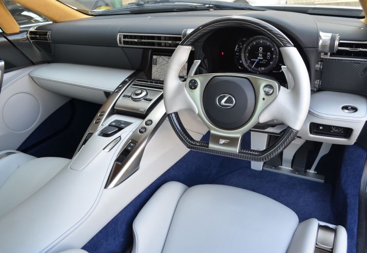 Intérieur de la Lexus LFA avec volant, compte-tours numérique et sellerie blanche