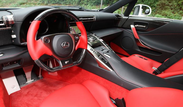 Habitacle de la Lexus LFA avec sièges sport rouges et poste de conduite orienté pilote.